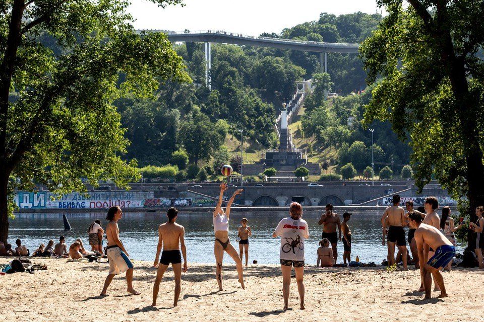 Young people play beach volleyball