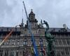 Crane hoists obelisk back onto the facade of Antwerp city hall after repairing storm damage: “The crown is back” (Antwerp)